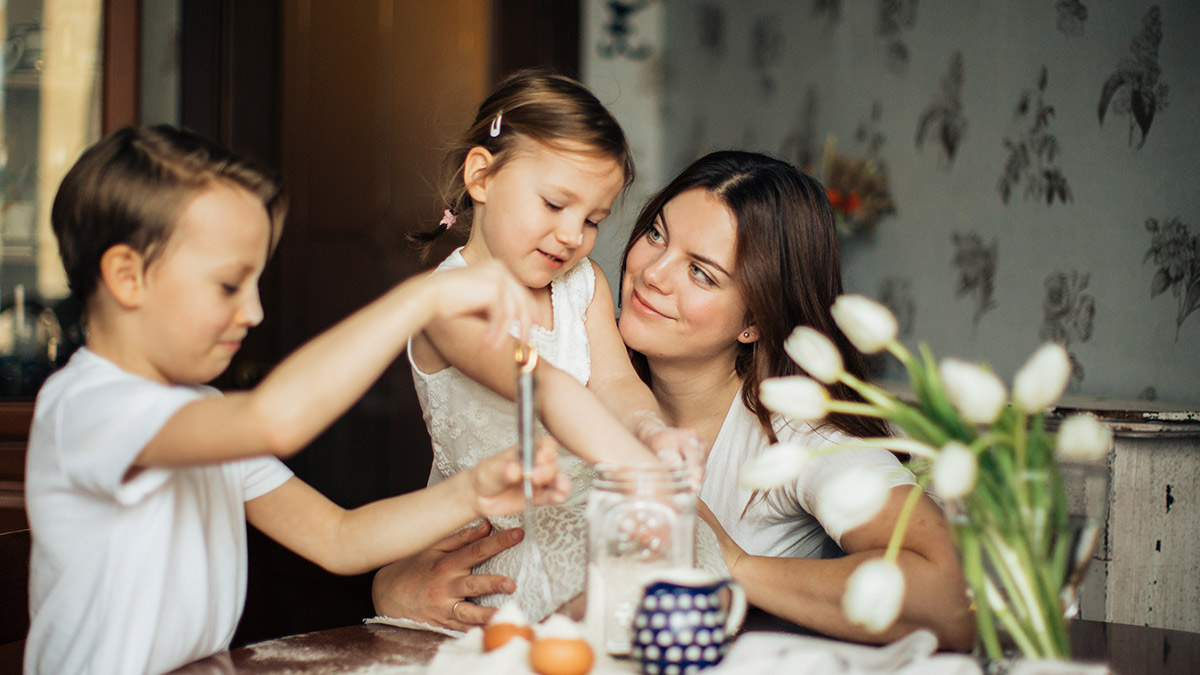 A foster carer baking at home with two children