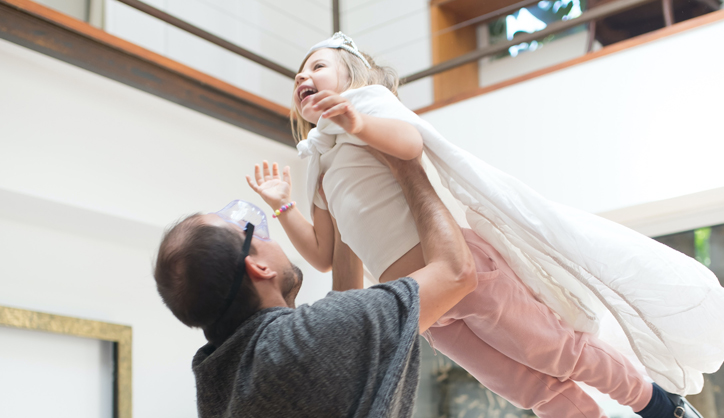 A foster dad lifting his daughter in the air